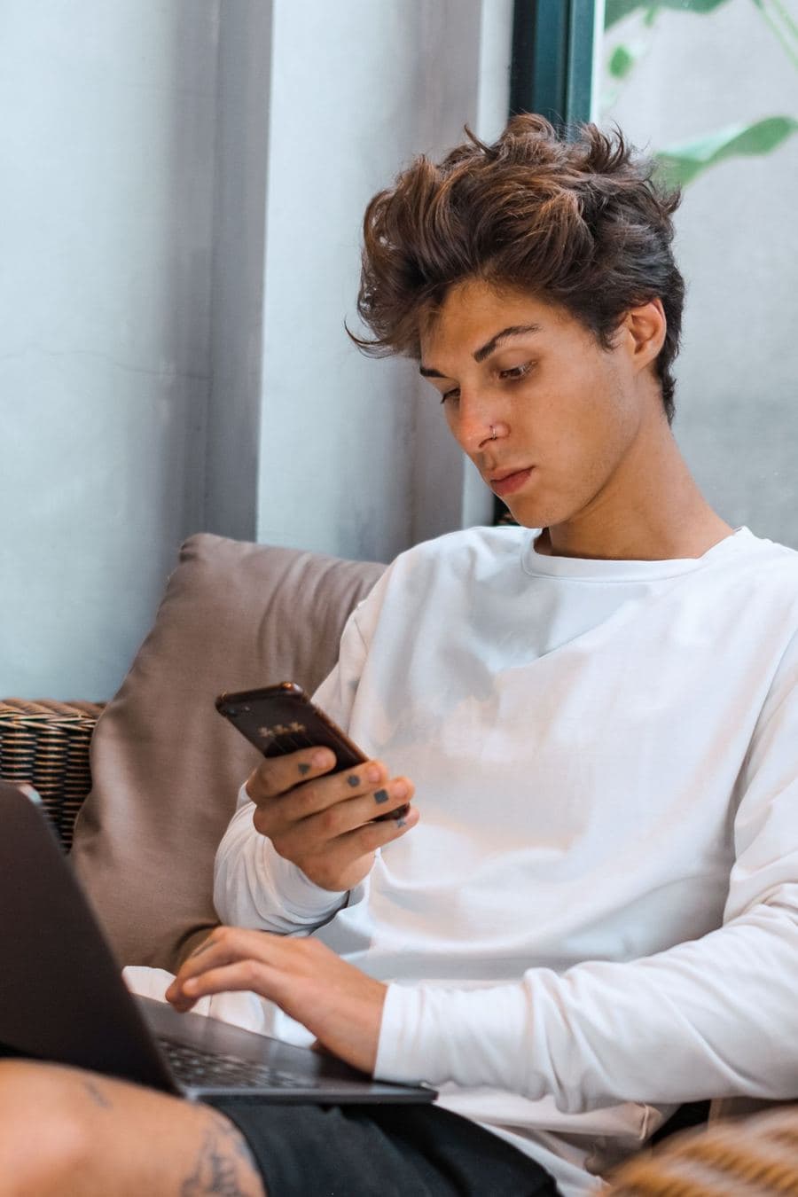 Young man checking his phone at home