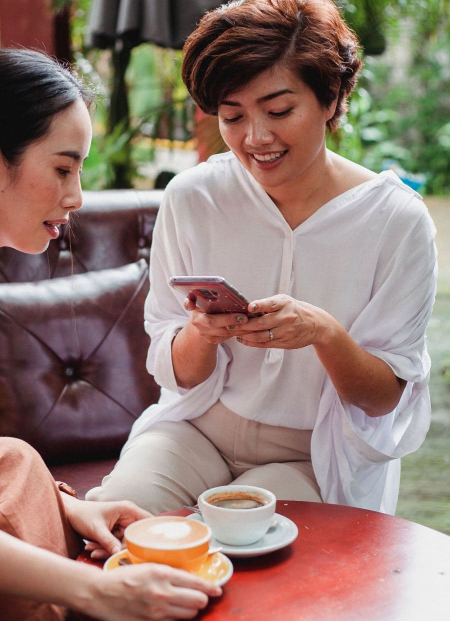 Woman smiling at her phone in a cafe